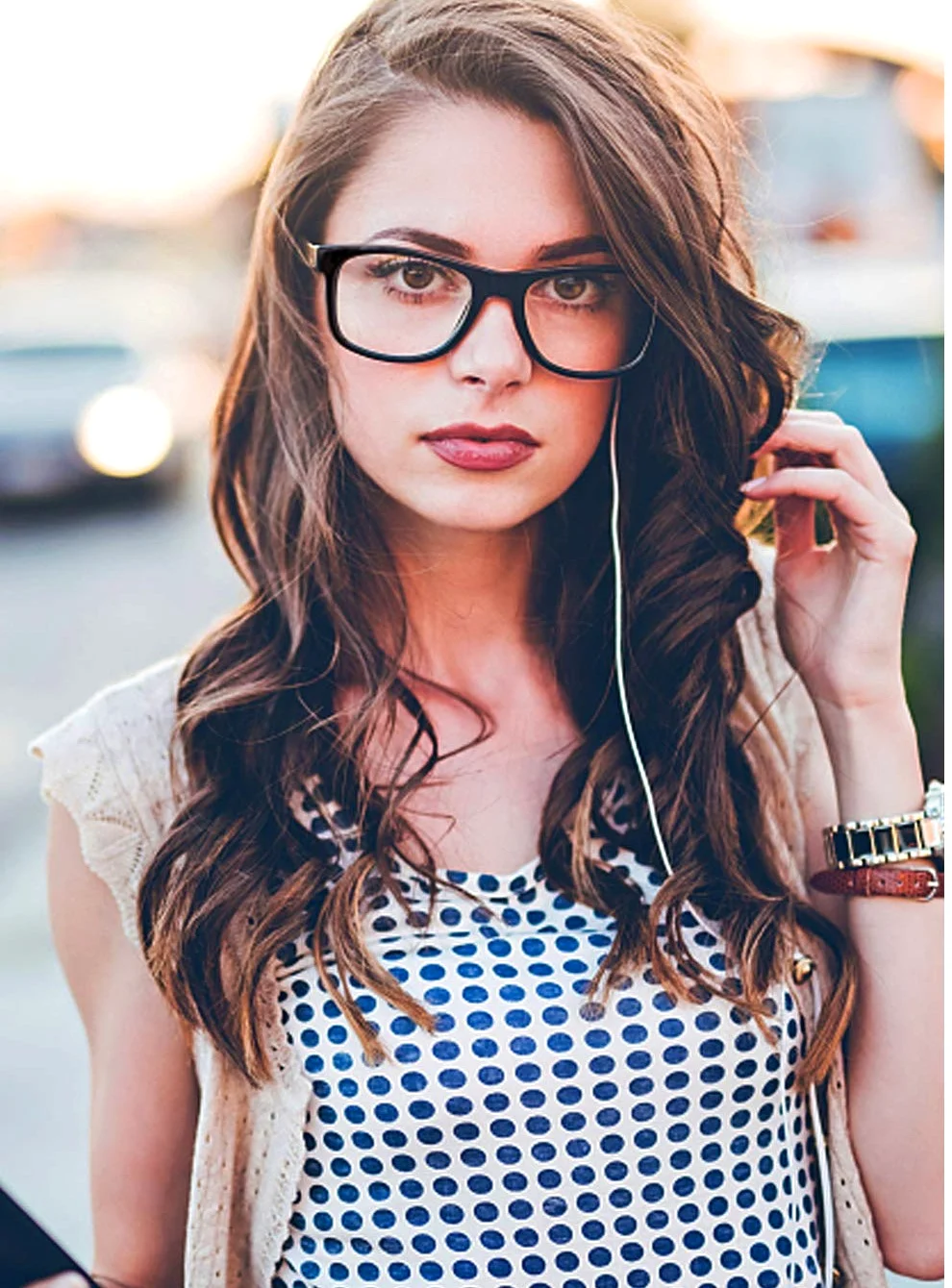 The rectangular clear-lens frame in matte black, on a city pavement